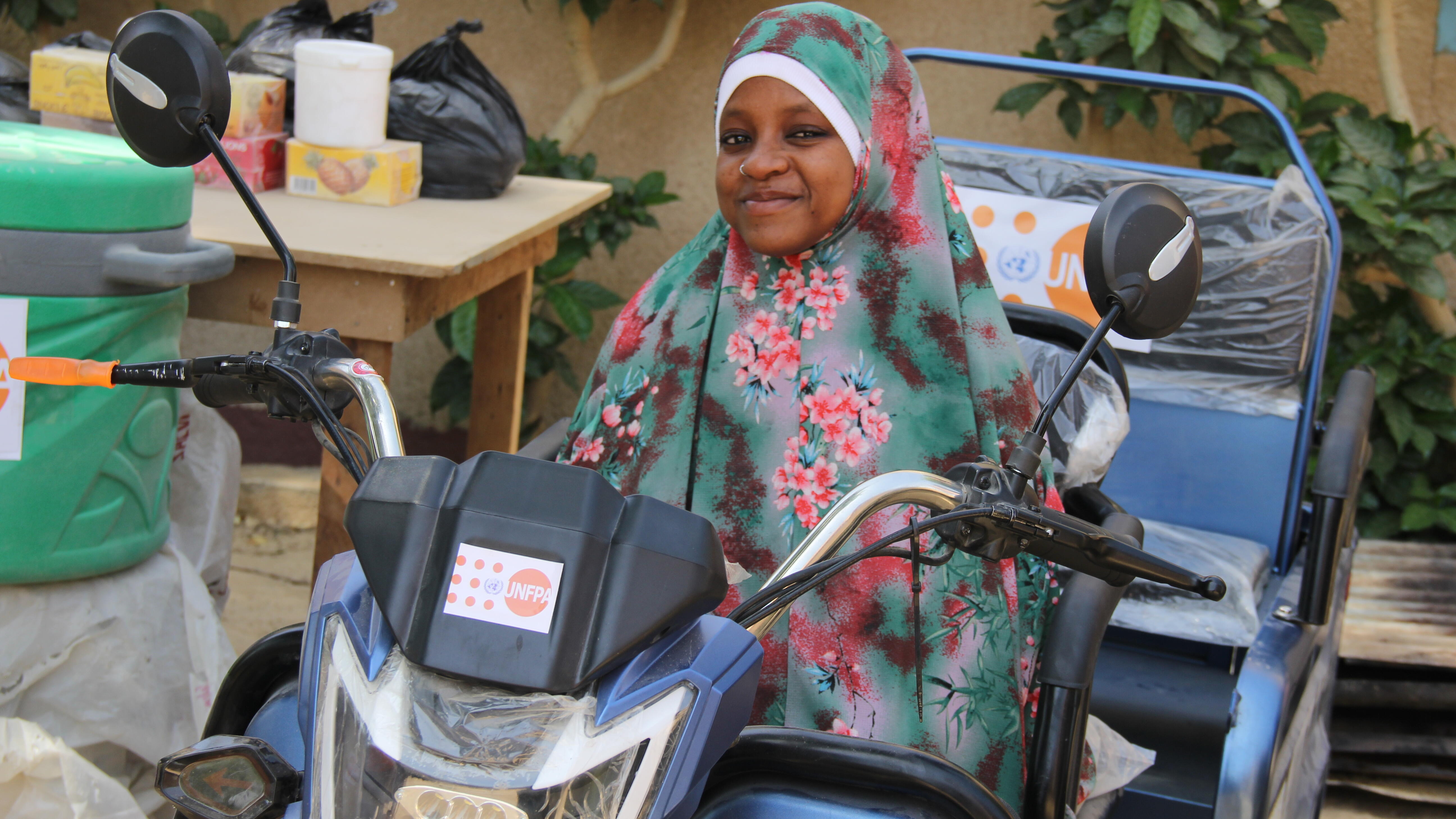 Ousseina sur sa nouvelle moto électrique