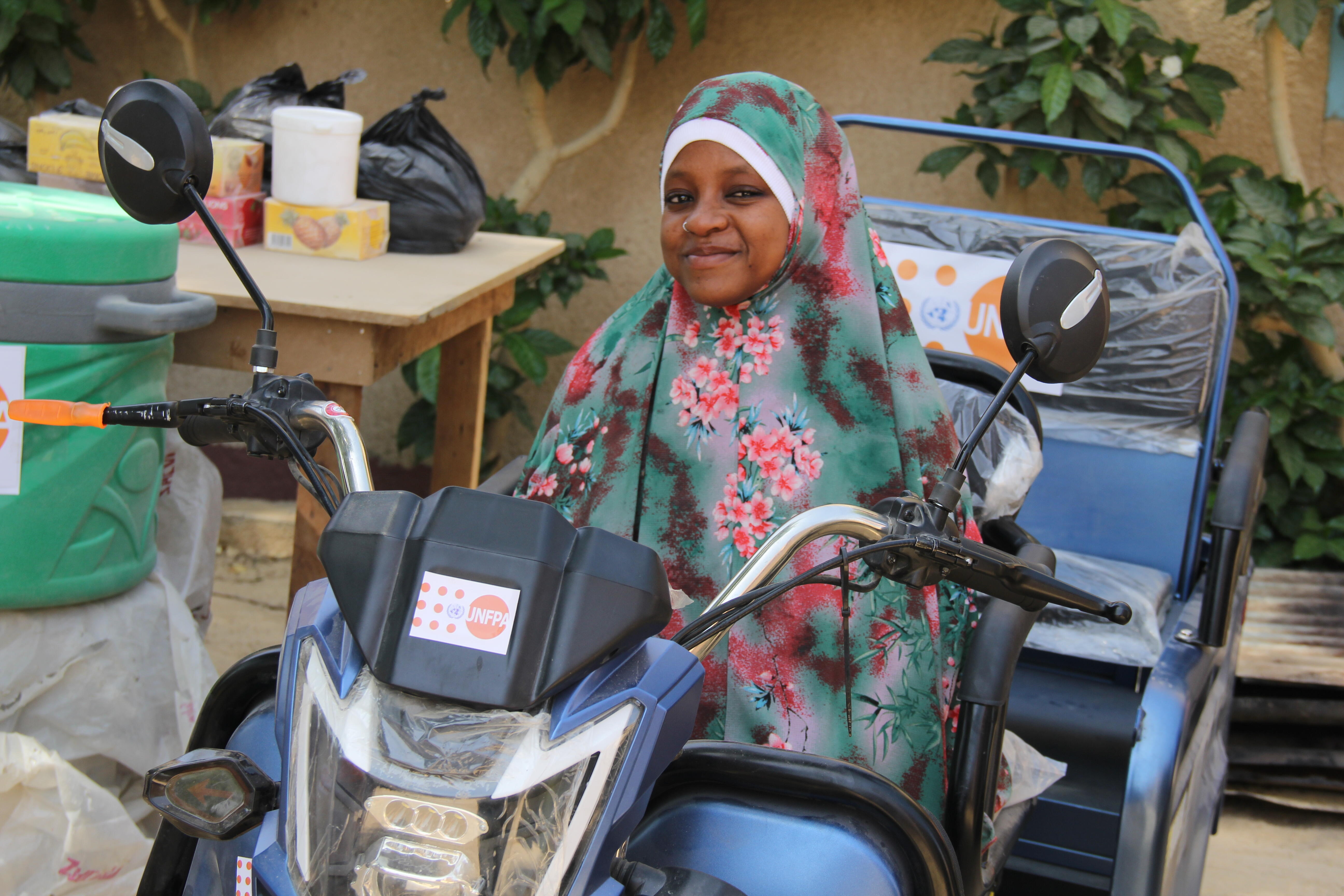 Ousseina sur sa nouvelle moto électrique