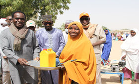 Le Représentant de l'UNFPA au Niger remettant un kit à une bénéficiaire en présence du Préfet du Département de Tessaoua